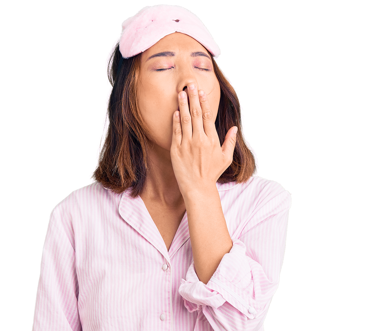 Woman wearing a pink sleep mask and pajamas, yawning