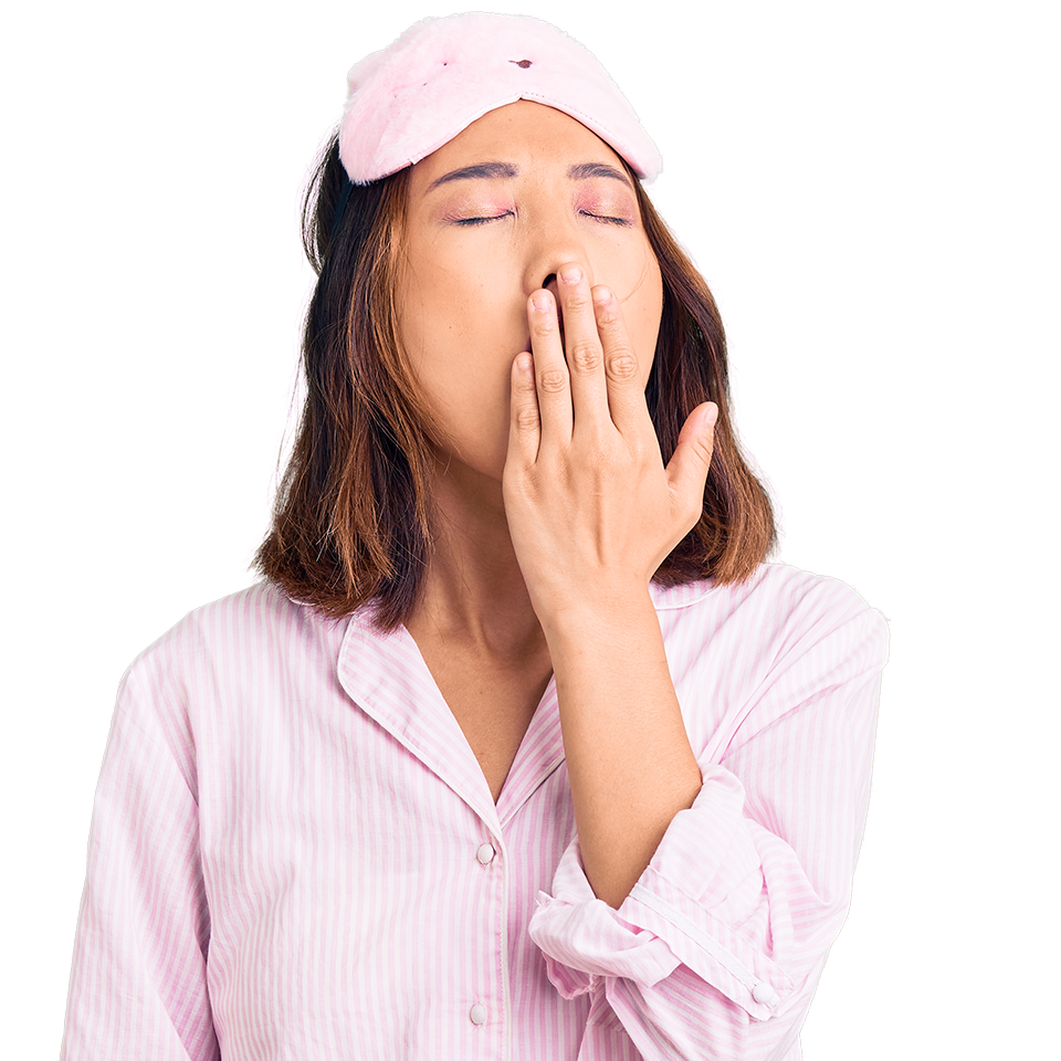 Woman wearing a pink sleep mask and pajamas, yawning