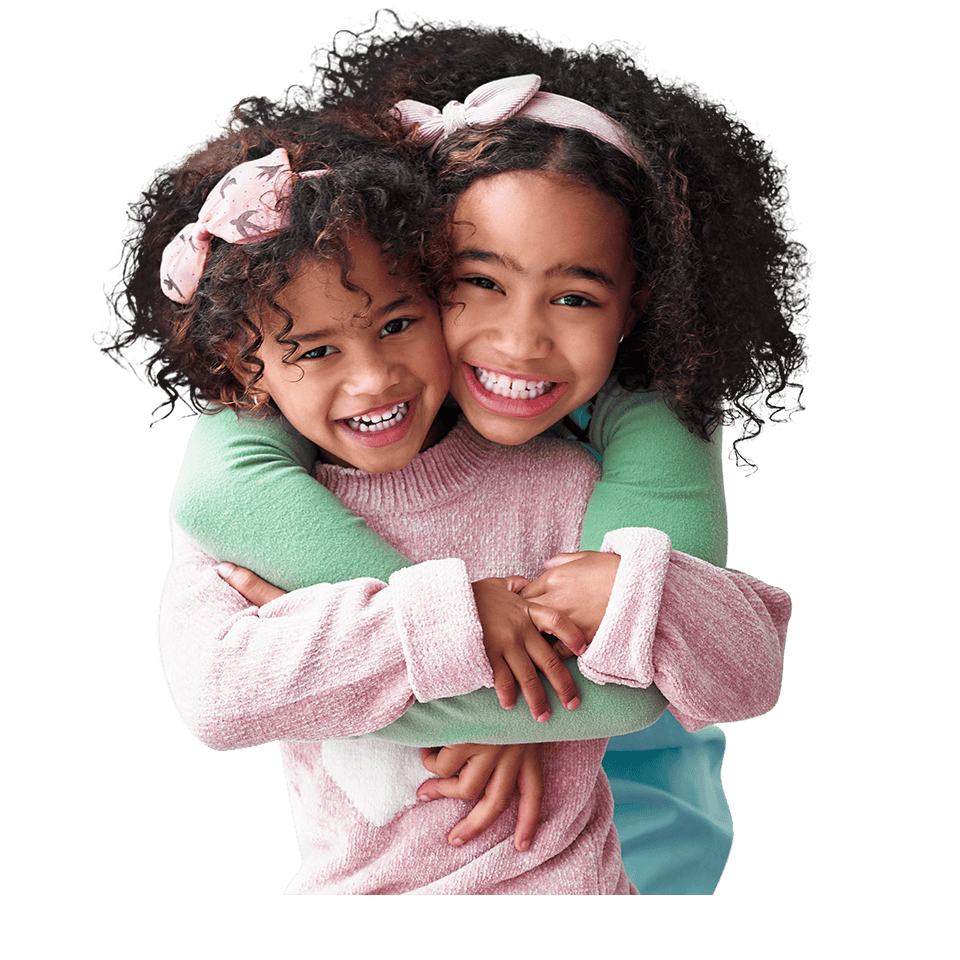 Two young girls hugging each other