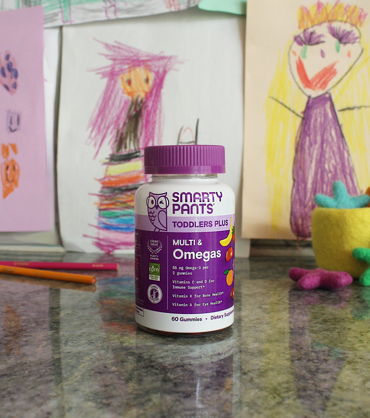toddlers plus multi omegas in front of children's drawings