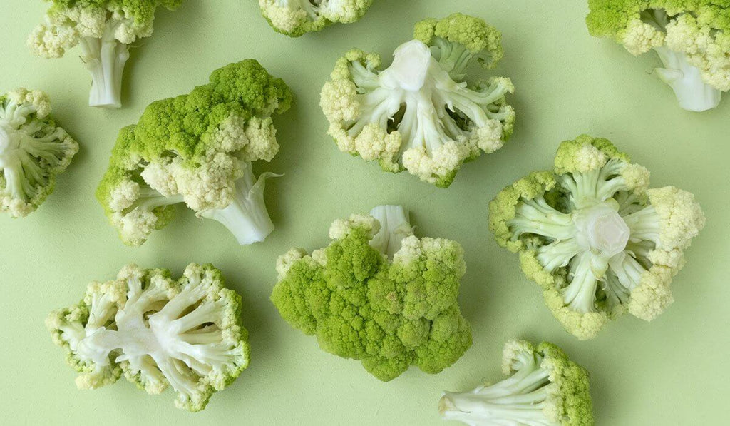 Slices of Cauliflower scattered in a  light green background