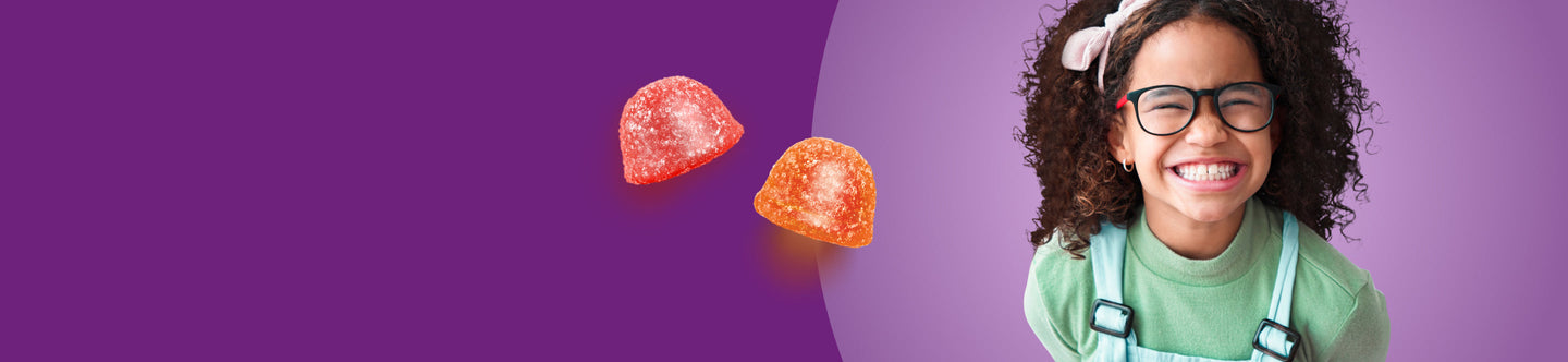 Young girl with glasses smiling against a purple background with gummy candies.