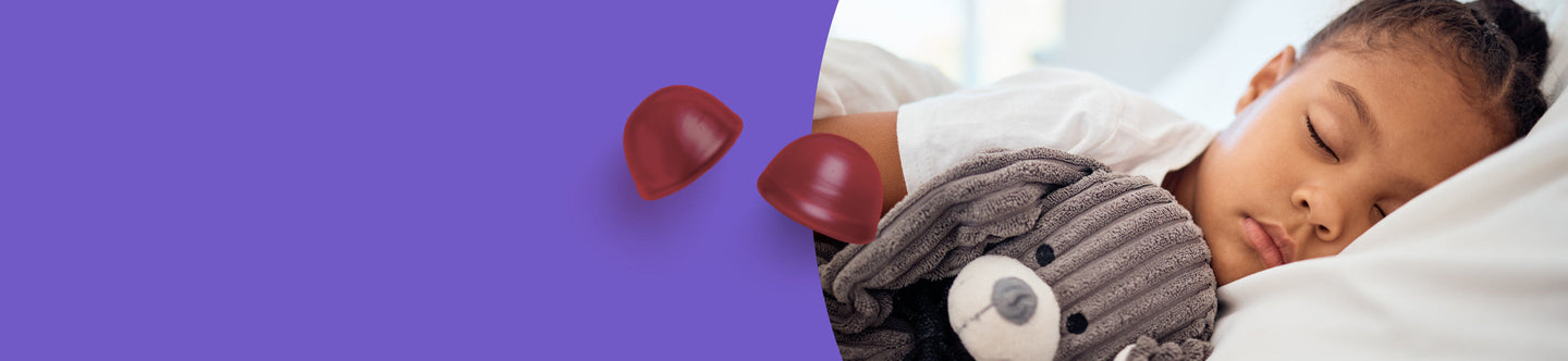 Child sleeping in bed with a teddy bear on a purple background