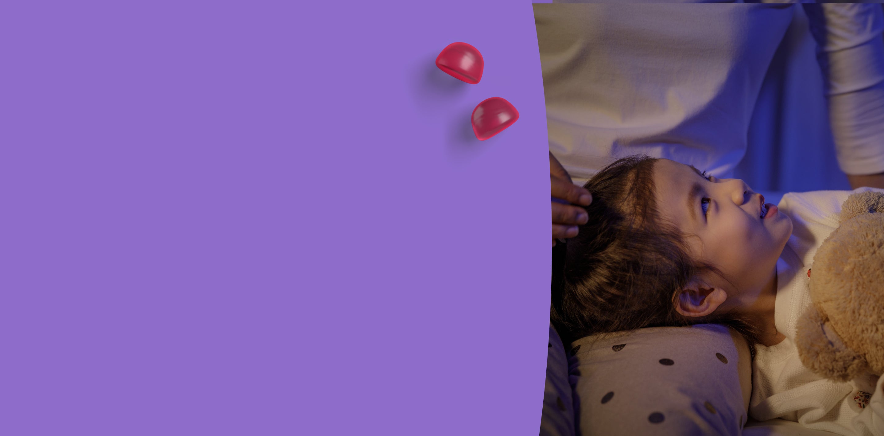 Child lying in bed with a teddy bear