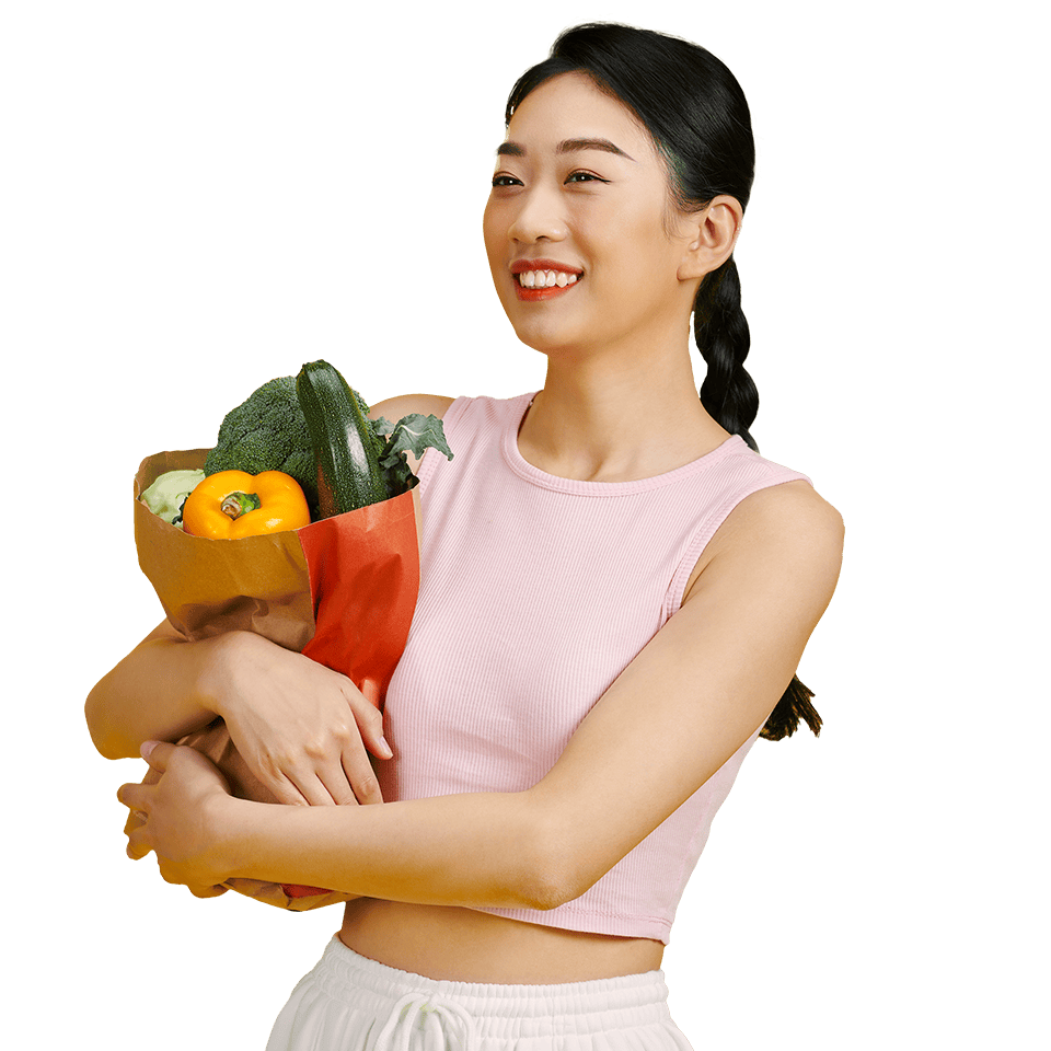 smiling woman holding bag of vegetables