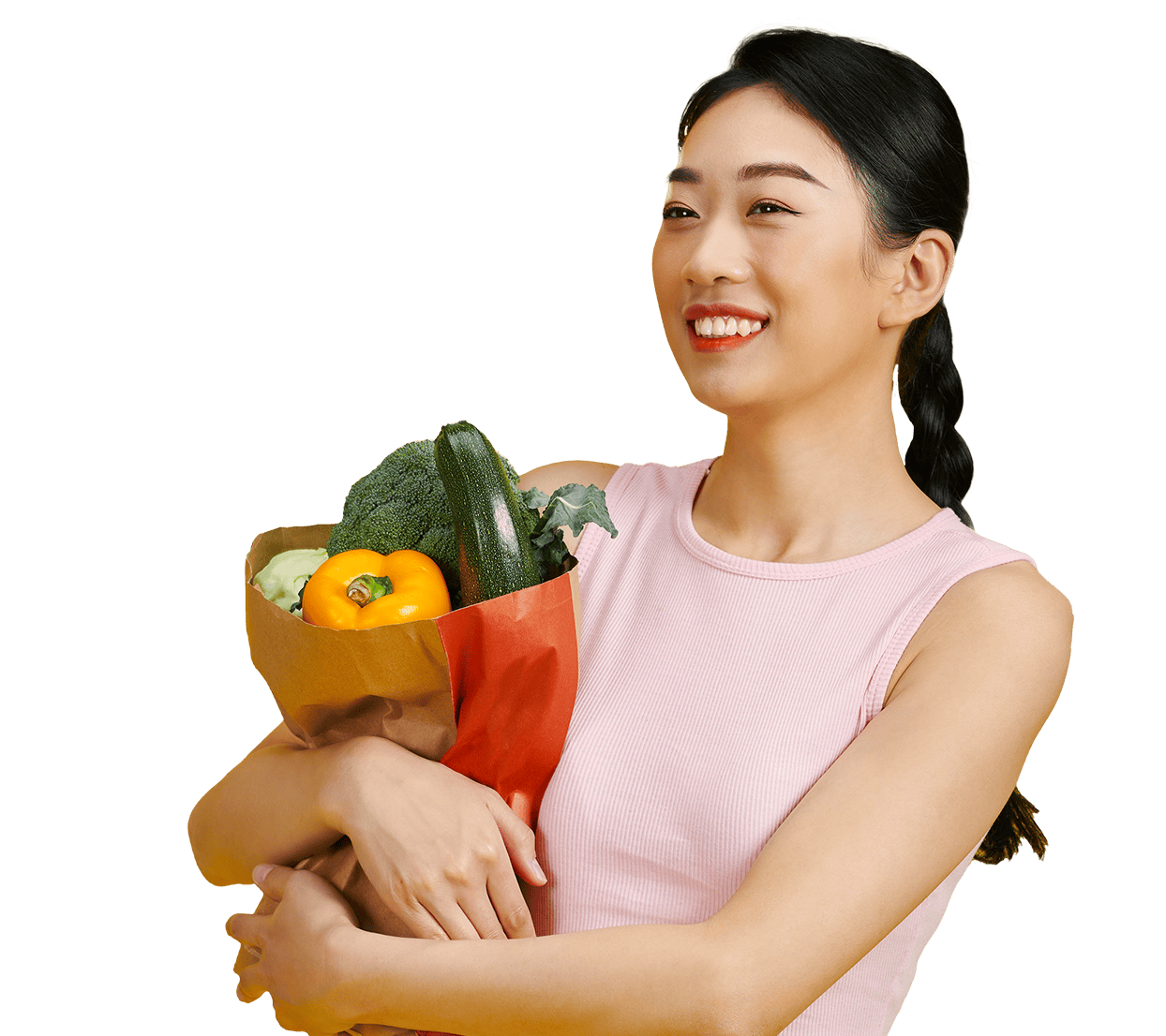smiling woman holding a bag of vegetables